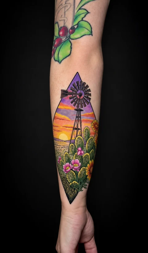 Windmill, sunset, cactus and flowers tattoo on a forearm